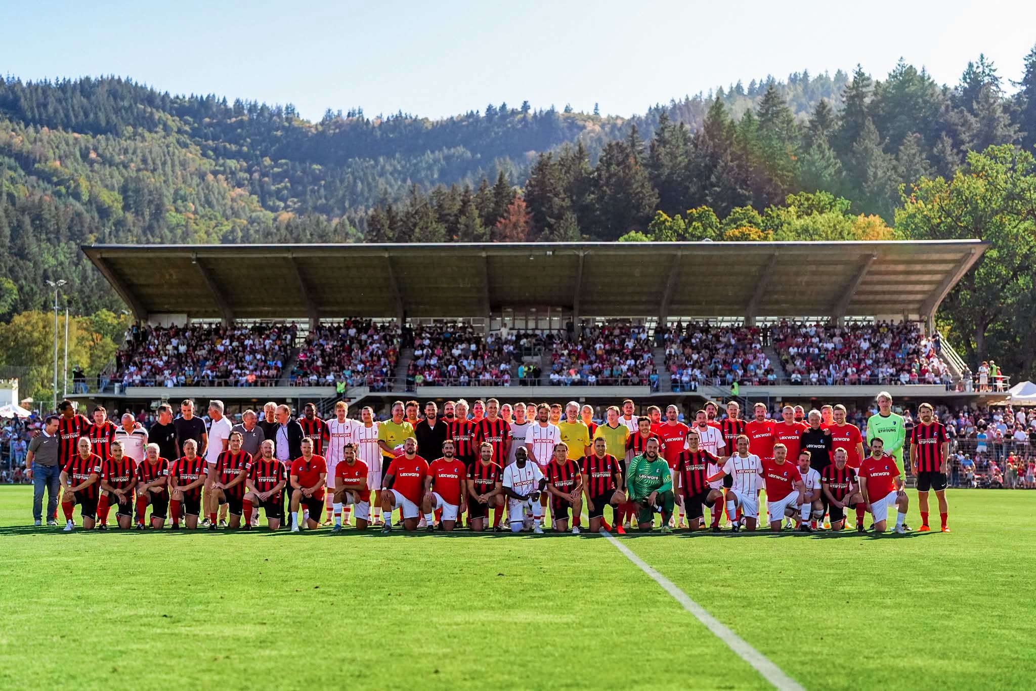 FFS-Auswahl und Traditionsmannschaft gemeinsam auf dem Rasen vor der besetzten Tribüne im Möslestadion.